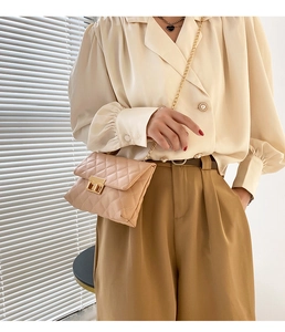Detailed view of beige quilted crossbody bag featuring gold chain strap and twist lock