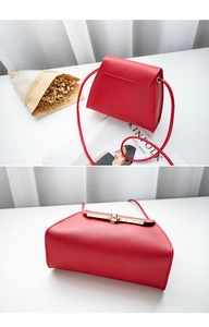 Close-up of red PU leather mini crossbody bag with golden metal twist lock and rings