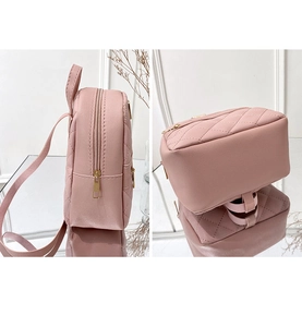 Detail view of pink quilted mini backpack with rhombic patterns and gold zippers