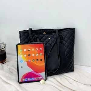 Black quilted tote bag with magnetic closure and large front pocket for women