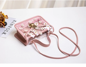 Detail of pink jelly bag with transparent daisy print PVC flap and gold metal clasp