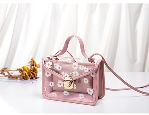 Detail of floral daisy print PVC jelly bag with pink leather inner pouch and metal clasp