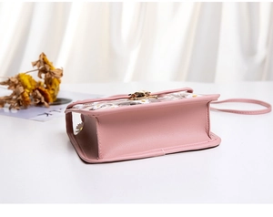 Detail view showing pink crossbody bag stitching and daisy print translucent flap