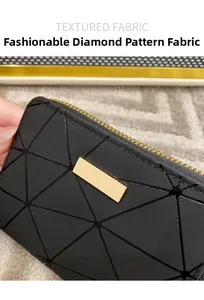 Détail du tissu noir matelassé à losanges avec plaque en métal doré sur le portefeuille