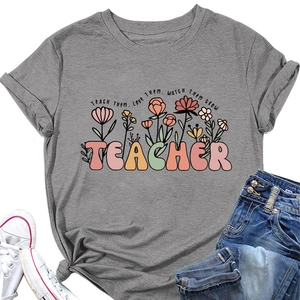 T-shirt enseignant gris foncé avec imprimé floral et citation en vue à plat