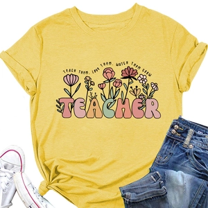 Détail d'un t-shirt jaune en coton avec texte TEACHER et motif floral coloré artistique