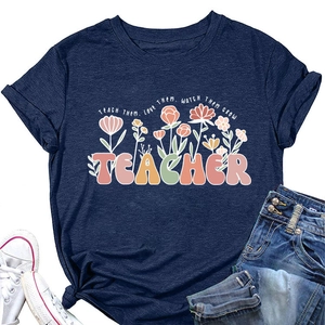 T-shirt bleu marine posé à plat avec slogan TEACHER et motifs graphiques floraux