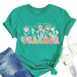 T-shirt vert pour enseignant avec imprimé floral et slogan Teach Them Love Them à plat