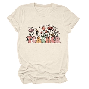 Détail du motif floral et texte TEACHER sur un t-shirt femme à col rond en coton
