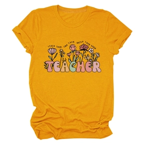 Détail du motif floral et texte Teach Them Love Them sur t-shirt jaune enseignant