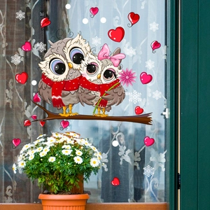Detail of cartoon owl window stickers with red hearts and snowflakes on glass