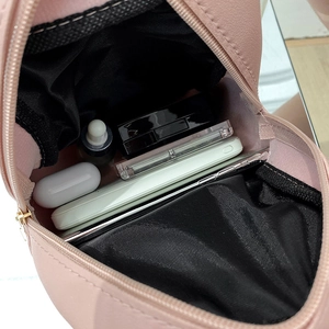 Pink quilted leather mini backpack showing interior space with phone and makeup essentials