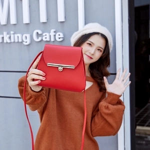 Minimalist red leather mini crossbody bag with gold metal clasp on model