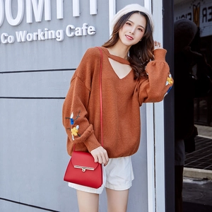 Women's orange V-neck knit sweater with floral embroidery and cutout collar detail