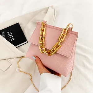 Detailansicht der rosa Trapez-Tasche mit goldener Acrylkette und Lychee-Korn-Struktur