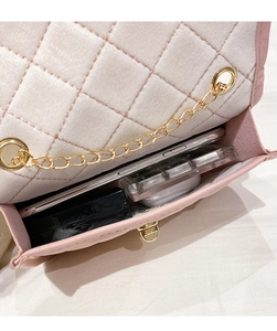 Detailed interior of the pink quilted bag showing phone and makeup storage space