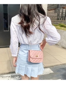 Detailed back view of a light pink quilted crossbody bag with a metal chain strap