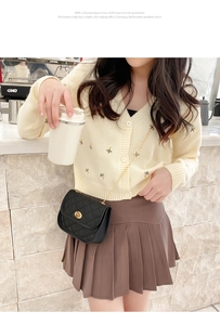 Close-up of quilted beige crossbody bag with metal lock and cold pressing process detail