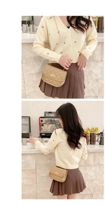 Close-up of quilted beige crossbody bag with gold chain strap in a cafe setting