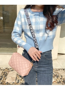Détail du sac caméra matelassé rose avec une large bandoulière brodée avec texte