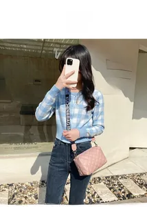 Détail du sac bandoulière rose matelassé avec une bandoulière tissée lettrée chic