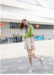 Outdoor-Modell mit pink-weißer Umhängetasche und lässigem Sommer-Outfit