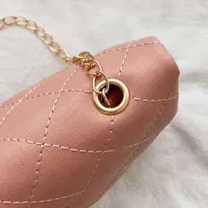 Detail of pink quilted handbag showing golden chain hardware and premium stitching texture