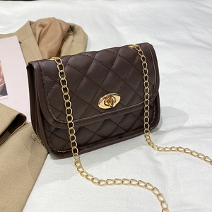 Deep brown quilted chain shoulder bag with golden twist lock on white fabric