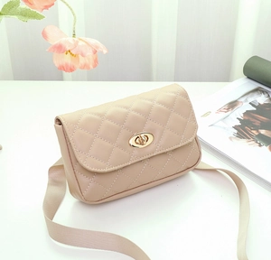 Détail du sac bandoulière matelassé beige avec fermoir tournant ovale doré en cuir PU