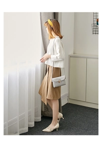 Chic light gray leather crossbody bag with metal lock shown with a full fashion outfit