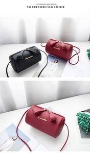 Detail of elegant litchi grain cylinder bags with bow knot and golden logo script