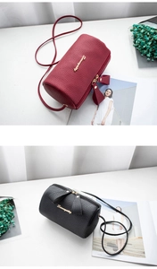 Detailed close-up of lychee grain leather mini barrel bags in black and burgundy red