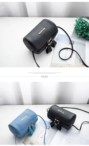 Detail of lychee pattern mini barrel bag with gold letter logo and slim leather strap