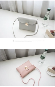 Detail of minimalist leather crossbody bags with metal clasp in grey and pink colors