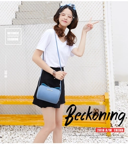 Close-up of light blue lychee pattern crossbody bag with decorative bow and gold logo