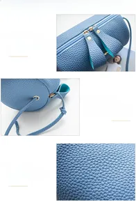 Detail of blue pebble grain texture and dual metal zippers on the mini cylinder bag