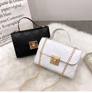 Detail van gewatteerde crossbodytassen met gouden sluitingen in zwarte en witte kleuren