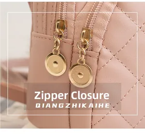 Detailansicht der rosa gesteppten Tasche mit goldenem Doppelreißverschluss und Anhängern