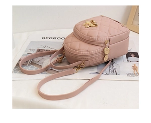 Detail eines rosa gesteppten Rucksacks mit goldenem Engelsverschluss und Reißverschluss