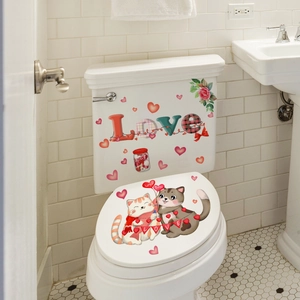 Detail of Valentine's Day cartoon cat and red heart toilet stickers on white ceramic