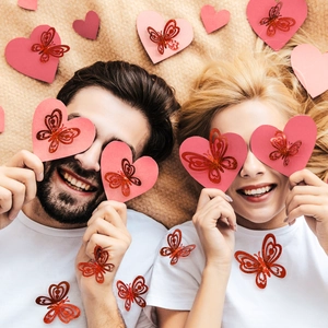 Macro shot of 3D cutout red butterfly wall stickers with gold glitter on heart decor