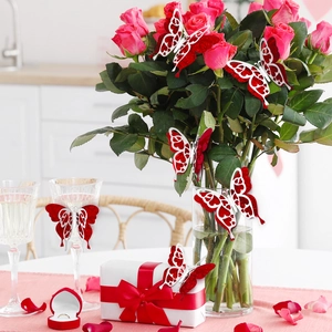 Close-up of 3D glittery butterfly decorations on rose bouquets and gift boxes