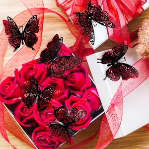 Detailed close-up of 3D layered red and black butterfly stickers with rose hollow patterns