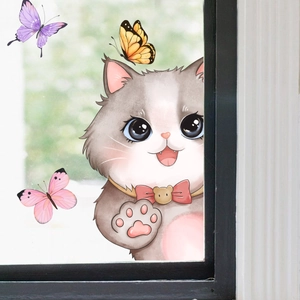 Detail von süßen Katzen- und Schmetterling-Fensteraufklebern auf Glas mit Gartenhintergrund