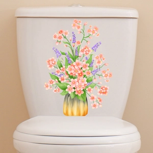 Floral wall sticker with pink flowers and gold vase on white bathroom toilet tank