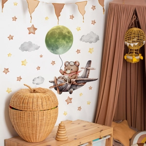 Cartoon bear on plane wall stickers with moon and stars in a cozy nursery room decor