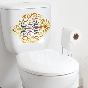 Detail eines goldenen Vintage-Blumenmusters auf einem weißen Toilettenspülkasten