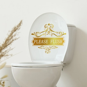 Detailansicht goldener Aufkleber mit Blumenmuster und 'Please Flush' Schriftzug