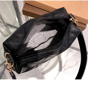 Détail du sac à bandoulière matelassé noir avec boucles dorées et doublure intérieure ornée