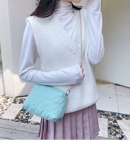Photo en extérieur d'un sac bandoulière matelassé bleu clair avec chaîne dorée